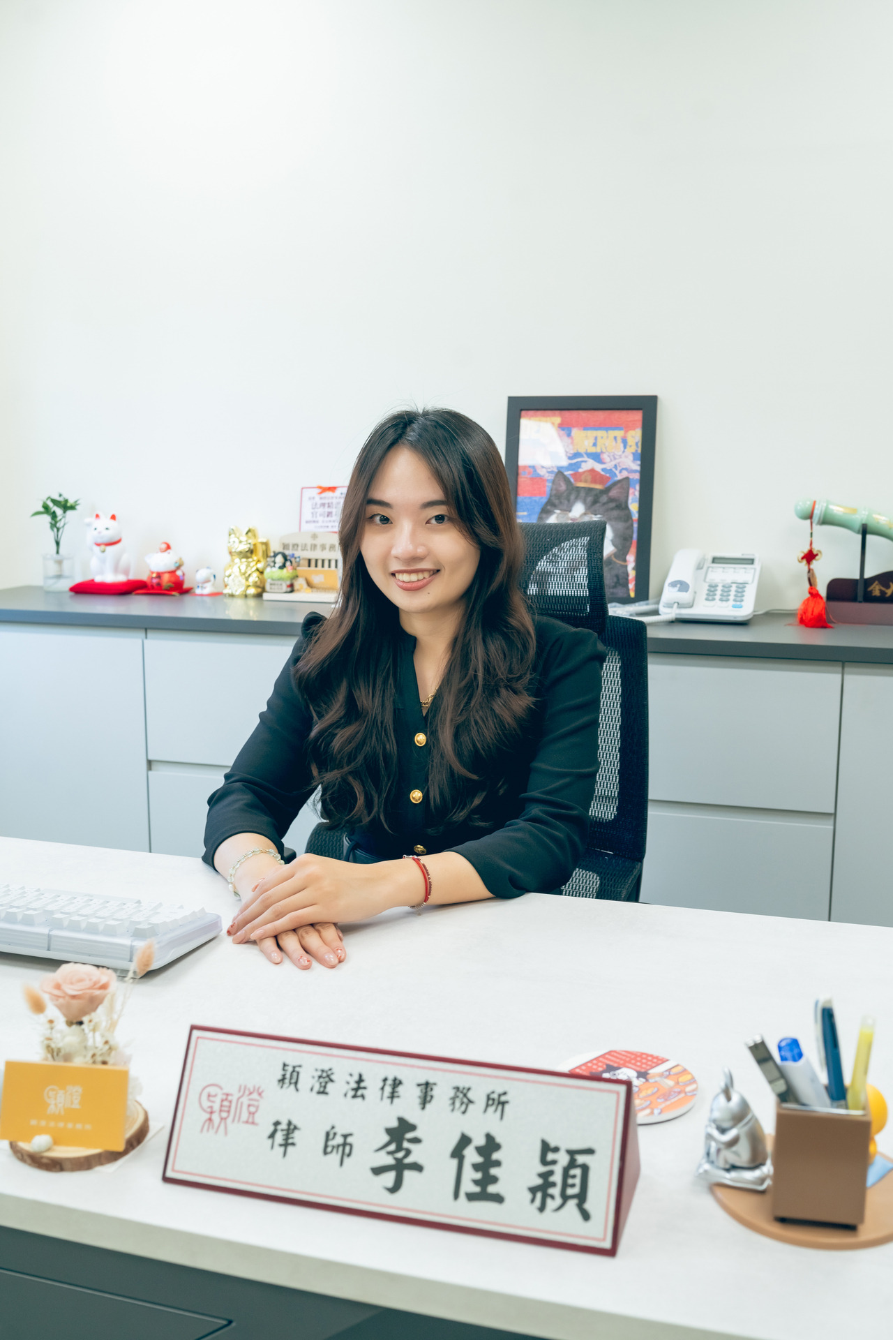 李佳穎律師在辦公室,桌上有名牌和各類裝飾品