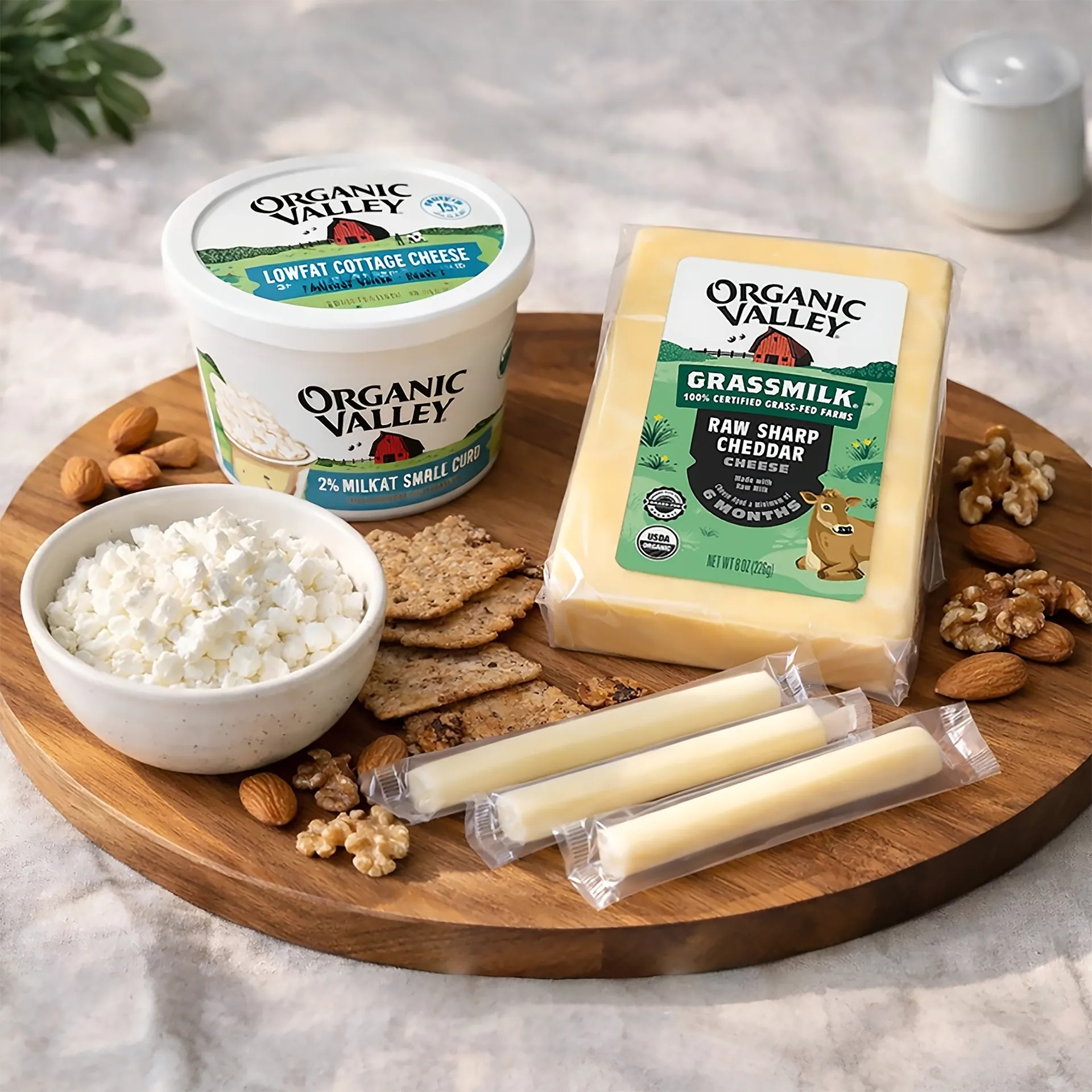 起司拼盤場景，木質餐盤上擺放三種 Organic Valley 起司：低脂茅屋起司、草飼切達起司塊與起司棒，搭配全麥餅乾與新鮮堅果點綴，呈現乳製品的天然質地與多樣化食用方式。