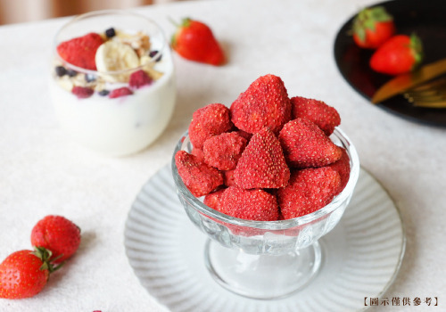 一碗玻璃碗裝著的凍乾台灣草莓，後面擺放一杯加入凍乾果乾的優格。