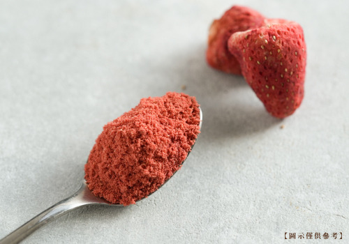 一匙冷凍乾燥純草莓粉，旁邊擺放凍乾草莓。