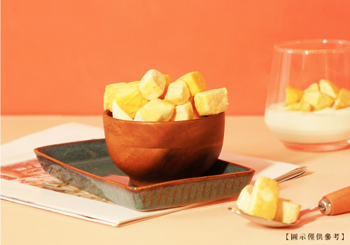 一碗以木碗盛裝的凍乾芒果果乾，旁邊擺放加入果乾的玻璃優格杯。