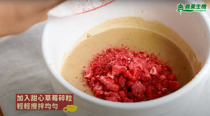 甜心草莓甜粿的製作步驟三，將凍乾草莓捏成碎粒狀後加入粉漿中並拌勻。