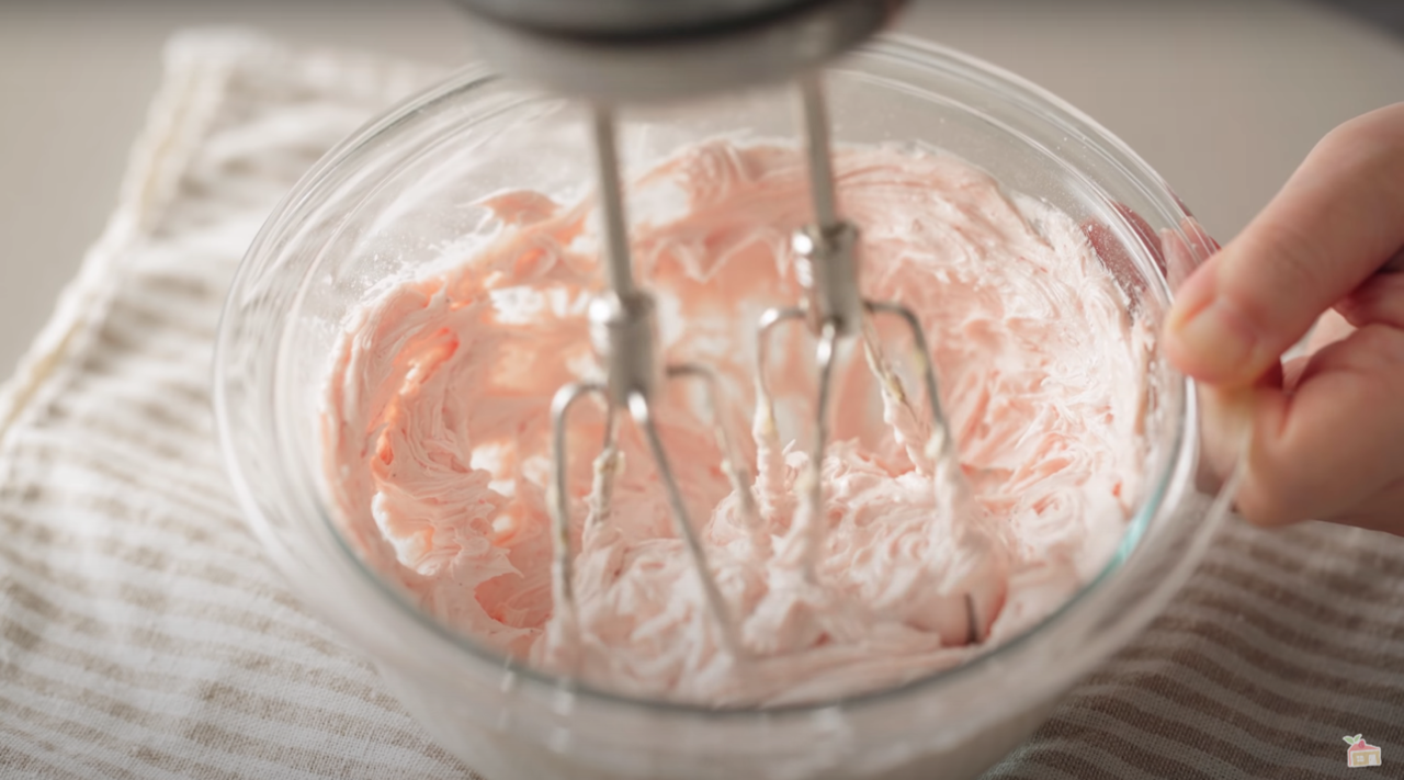 草莓夾心餅乾的製作步驟八，加入融化好的白巧克力及放置室溫的鮮奶油拌勻。