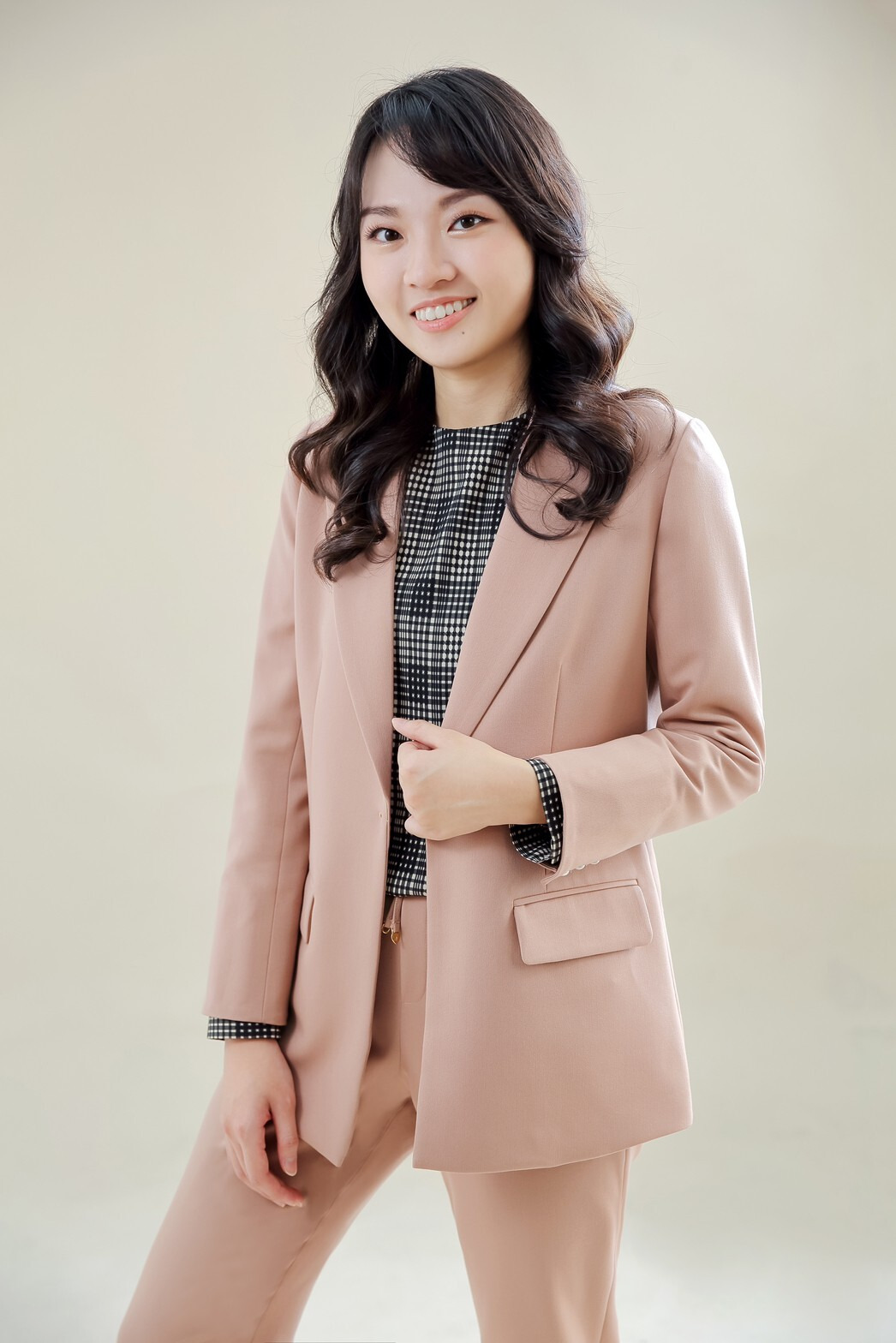 李佳穎律師全身照，面帶微笑，身穿粉色西裝