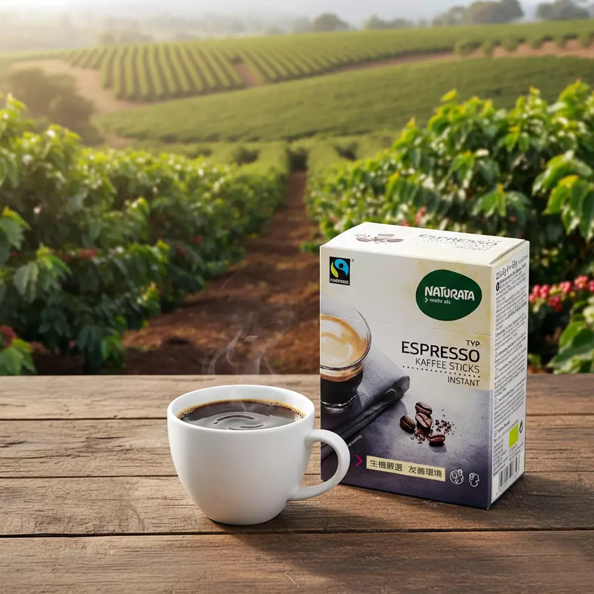 非洲小農咖啡樹園背景前景木桌上擺放一杯正在攪拌的黑咖啡，旁邊放置Naturata 義式濃縮即溶咖啡產品外盒包裝，呈現自然純淨與生態種植理念的安心氛圍。