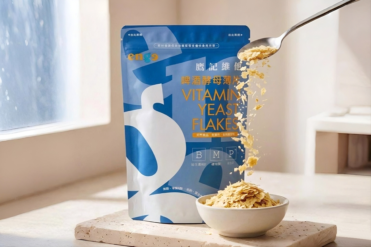 鷹記維他啤酒酵母薄片產品圖，金黃色酵母薄片從湯匙灑落，呈現薄片酥脆質地與自然純淨風格。