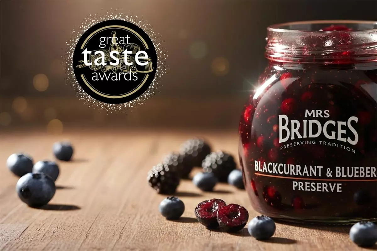 MRS. BRIDGES黑醋栗藍莓果醬微距攝影，玻璃瓶充滿深寶石紅果醬，左上方Great Taste Award獲獎標誌，陽光捕捉光澤質感，背景柔焦新鮮漿果，電影級燈光。