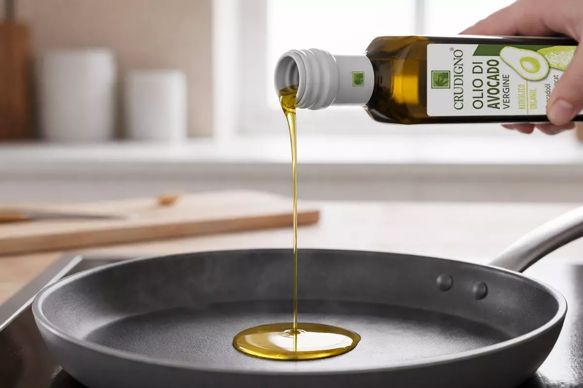 微距寫實畫面捕捉CRUDIGNO義大利酪梨油細緻金黃色油流倒入預熱平底鍋瞬間，油質清澈無混濁、幾乎無煙僅有輕微熱氣波動，鍋面乾淨無焦痕與油爆，整體為明亮自然廚房光線，呈現高發煙點、清爽不油膩的專業料理質感。