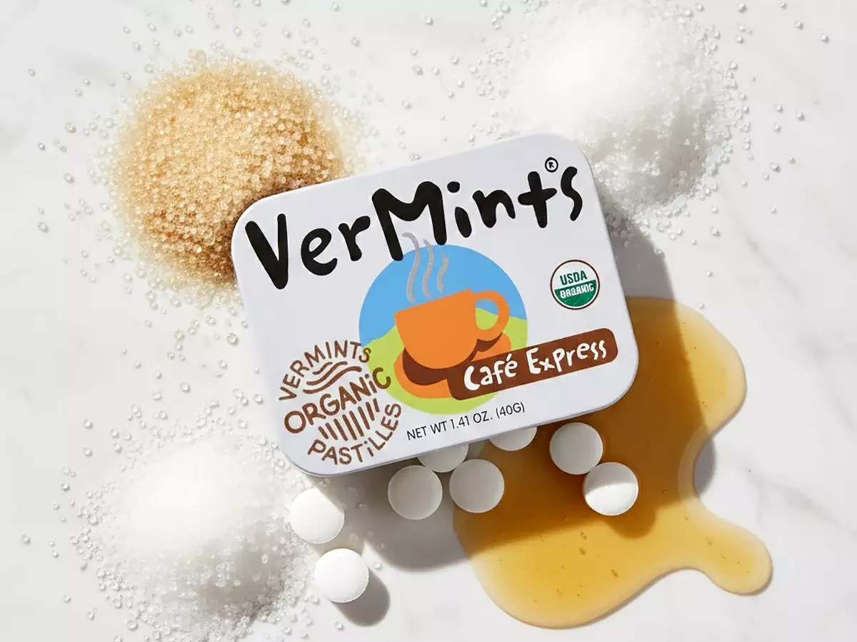 VerMints有機清口糖咖啡風味鐵盒實品圖，平鋪展示結晶蔗糖、木薯糖漿與USDA有機認證標章。純白大理石面、自然光線、無化學添加純淨可信賴感。